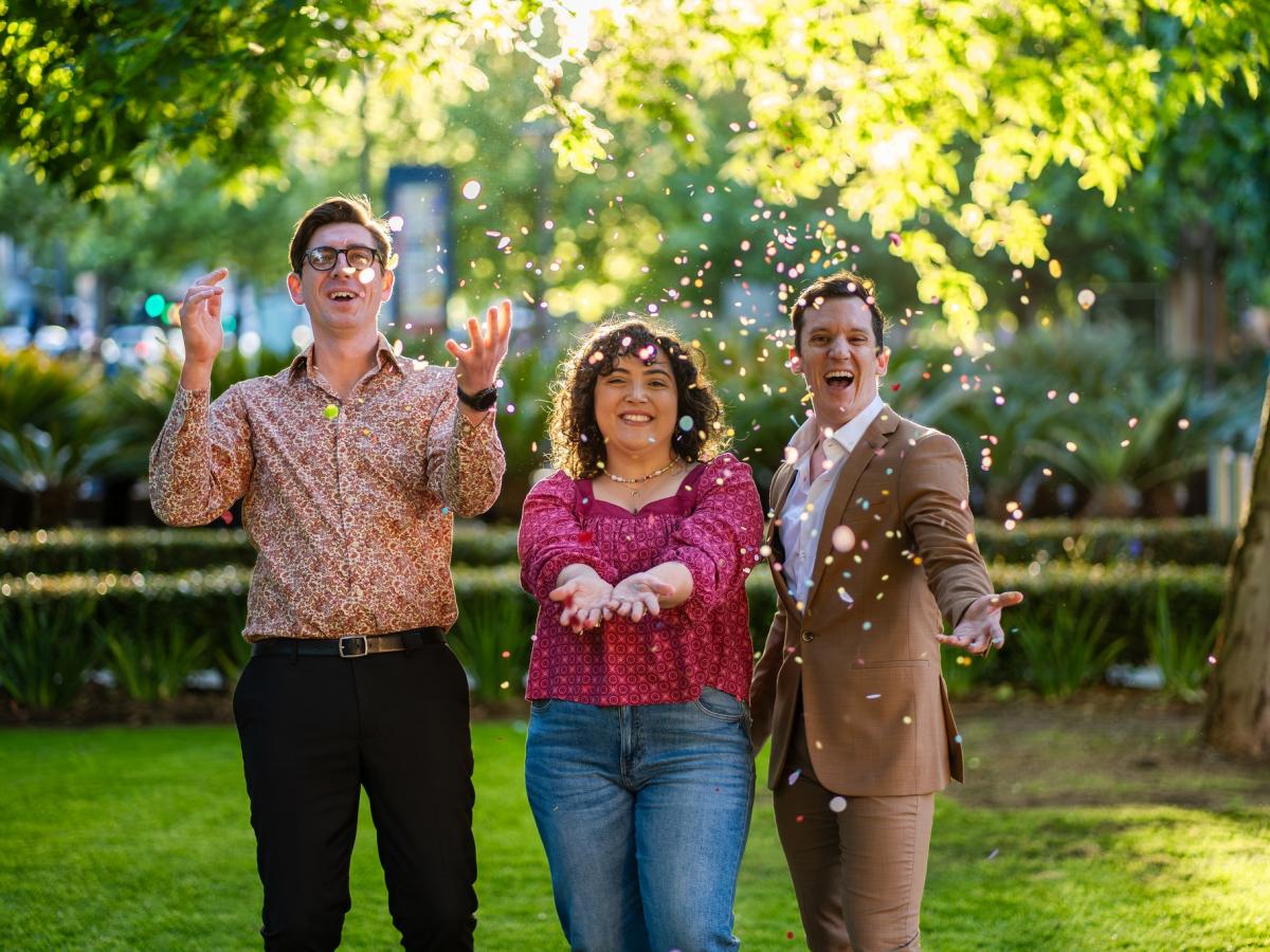 Three people celebrate outside with sparkles!